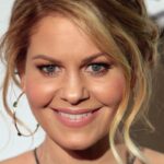 Candace Cameron Bure sorrindo em evento, com vestido verde