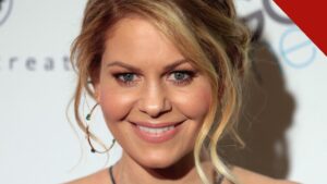 Candace Cameron Bure sorrindo em evento, com vestido verde
