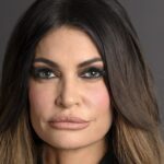 Retrato oficial de Kimberly Guilfoyle, embaixadora dos Estados Unidos na Grécia, diante da bandeira americana