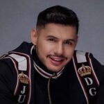 Hungria é o único: o rapper Hungria Hip Hop sorrindo em retrato de estúdio com jaqueta preta