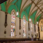 Interior de uma igreja nos Estados Unidos com bancos vazios e vitrais coloridos