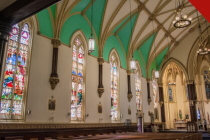 Interior de uma igreja nos Estados Unidos com bancos vazios e vitrais coloridos