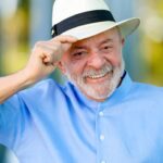 Repercussão internacional da vitória de Lula: o presidente sorrindo e segurando a aba do chapéu em foto oficial
