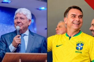 Reverendo Hernandes Dias Lopes pregando ao microfone ao lado de Flávio Bolsonaro sorrindo com a camisa da seleção brasileira