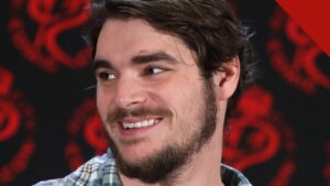 RJ Mitte sorrindo durante evento com fãs, de camisa xadrez