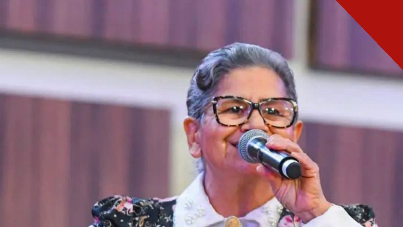 Sara Araújo cantando com microfone em apresentação recente