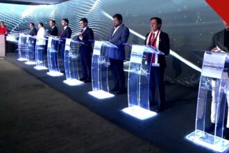 Palco de debate presidencial com candidatos nos púlpitos