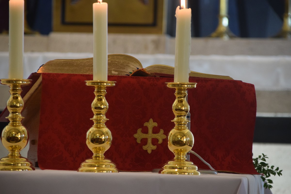ex-líder satânico alerta cristãos sobre o Halloween, e a imagem mostra velas acesas em um altar de igreja, em referência à resposta de oração e adoração defendida pelo ex-líder em sua entrevista