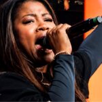 Cantora Joane Rodrigues cantando com microfone