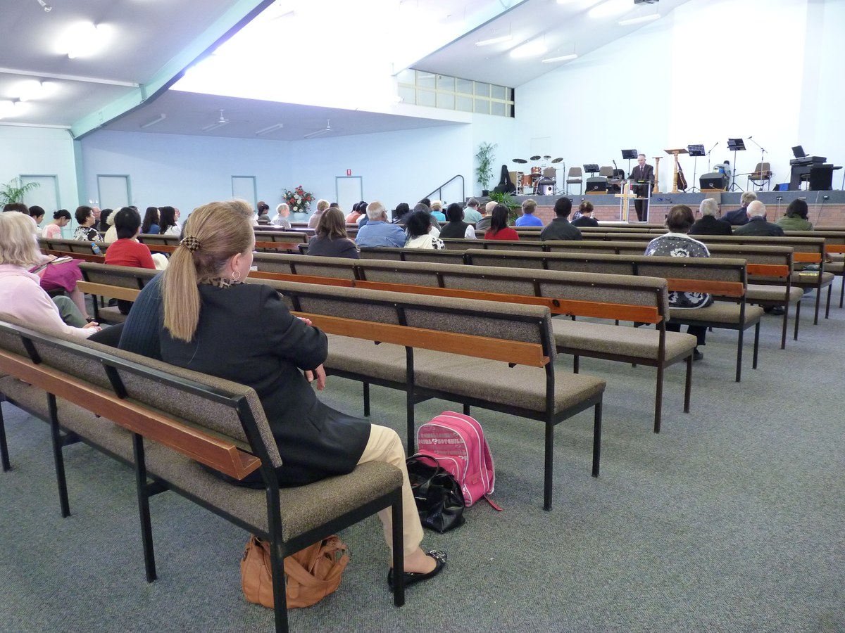 jovens adultos frequentam cultos mais que os pais, e a imagem mostra jovens reunidos em um culto nos Estados Unidos, com as mãos levantadas em adoração