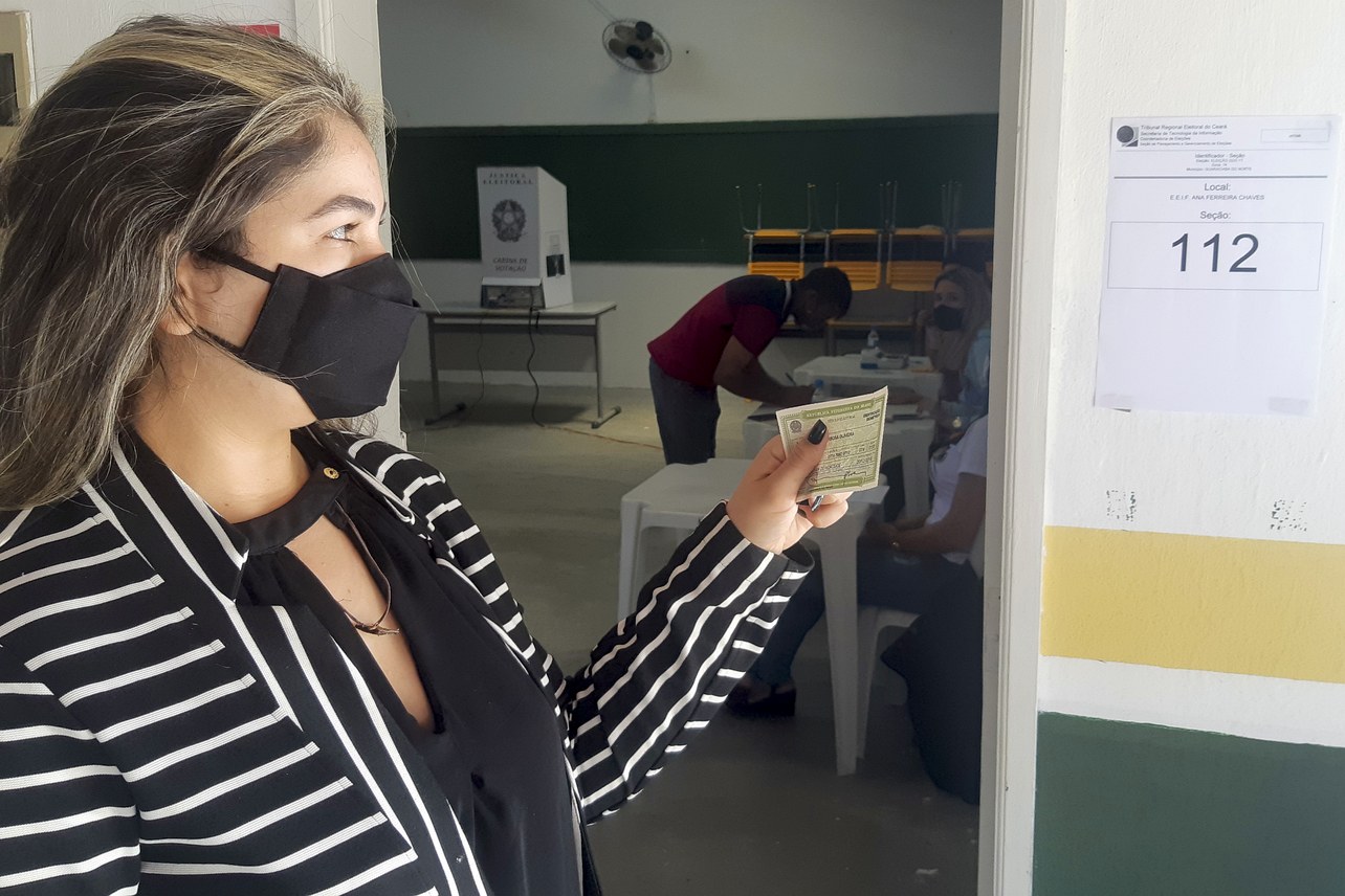 Eleitora apresenta documento com foto na entrada de uma seção eleitoral no Ceará