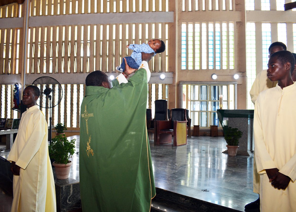 Fiéis em igreja católica na Nigéria durante celebração com crianças e comunidade reunida