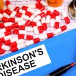 Comprimidos e estetoscópio sobre mesa com etiqueta Parkinson's Disease
