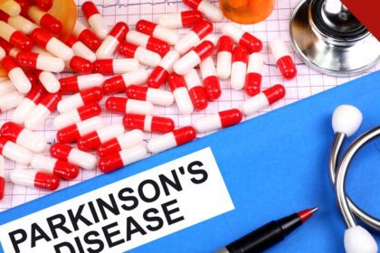Comprimidos e estetoscópio sobre mesa com etiqueta Parkinson's Disease
